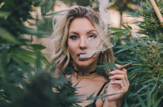 weed strains - beautiful woman smoking weed amongst cannabis plants